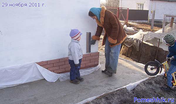 Валерия счищает с фасада брызги бетона